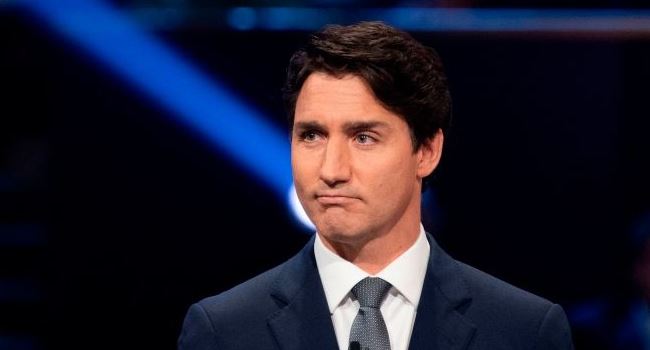 Scandal-scarred Trudeau retains power in Canada but loses majority