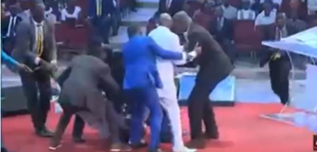 Man beats security, grabs leg of Bishop Oyedepo on pulpit (VIDEO)